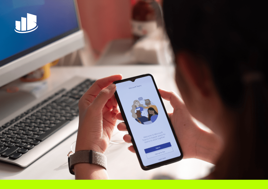 Person using Microsoft Teams app on a smartphone in a modern office setting, highlighting seamless telephony integration and collaboration tools.