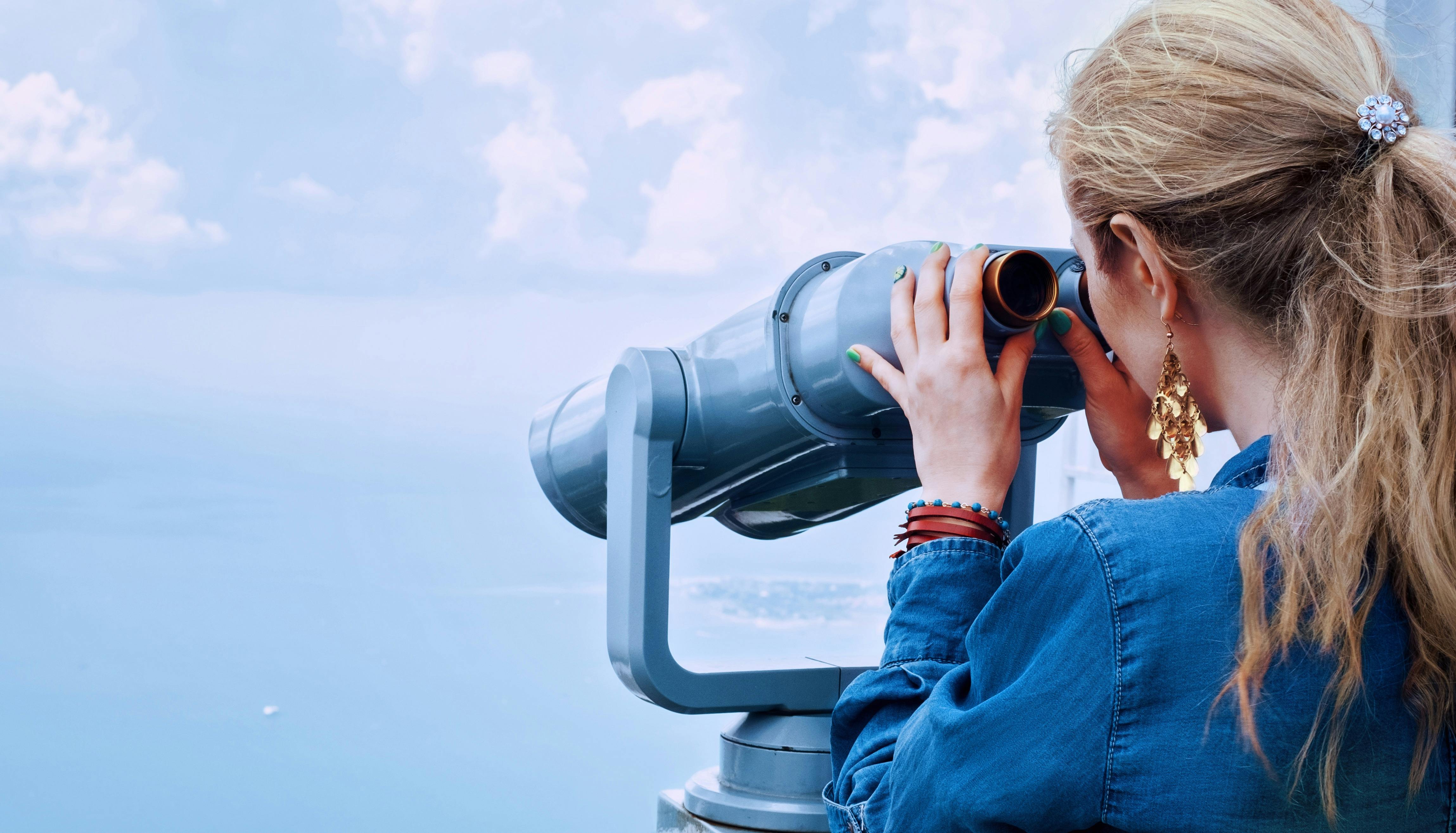 Future of Cloud Communications. A person looking through a telescope.