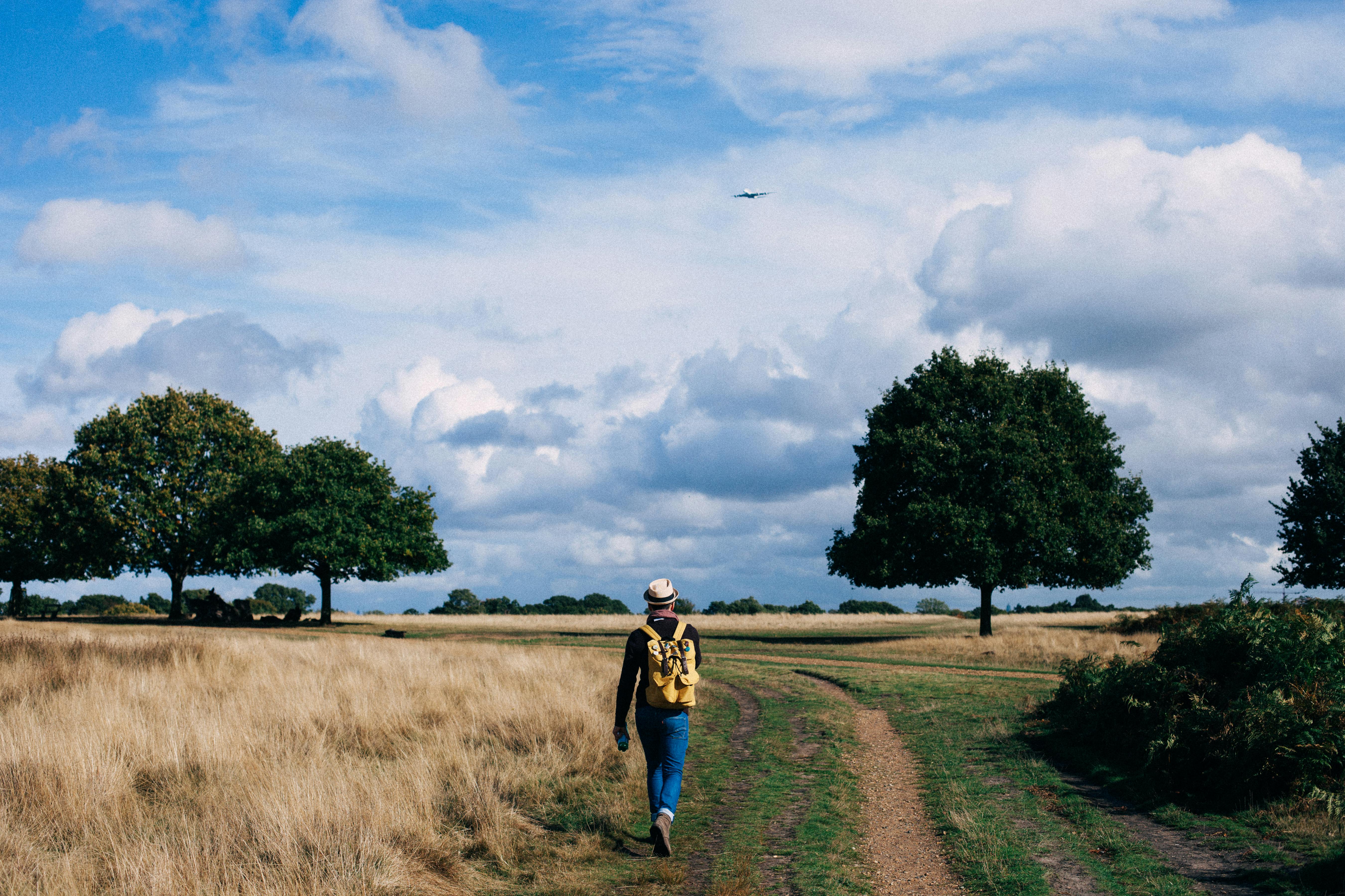 Microsoft Teams standalone. A hiker with a backpack strolling along a dusty path in the countryside.