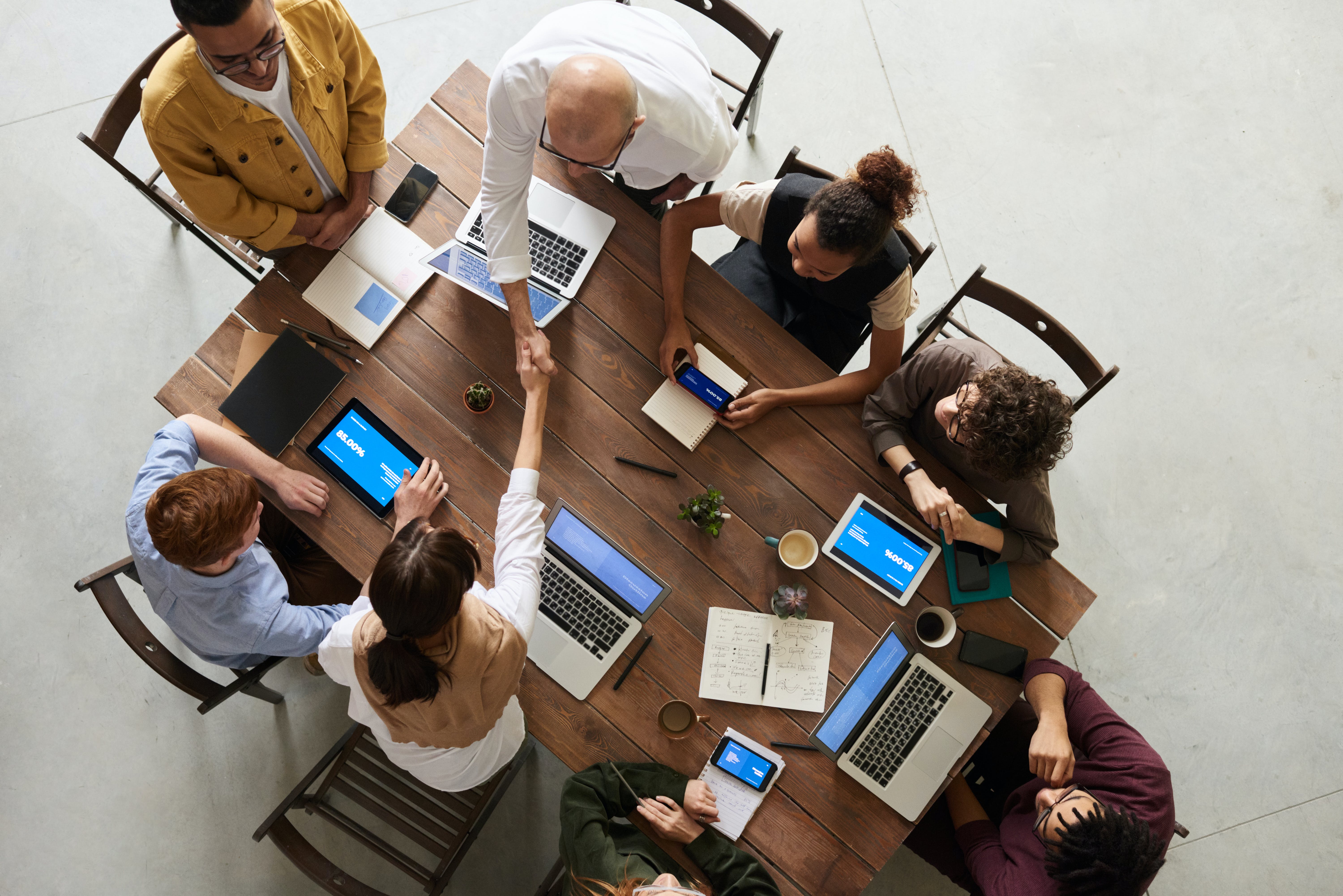 Integration Trends: Boosting Unified Communication Efficiency. A group of people with laptops around a table.