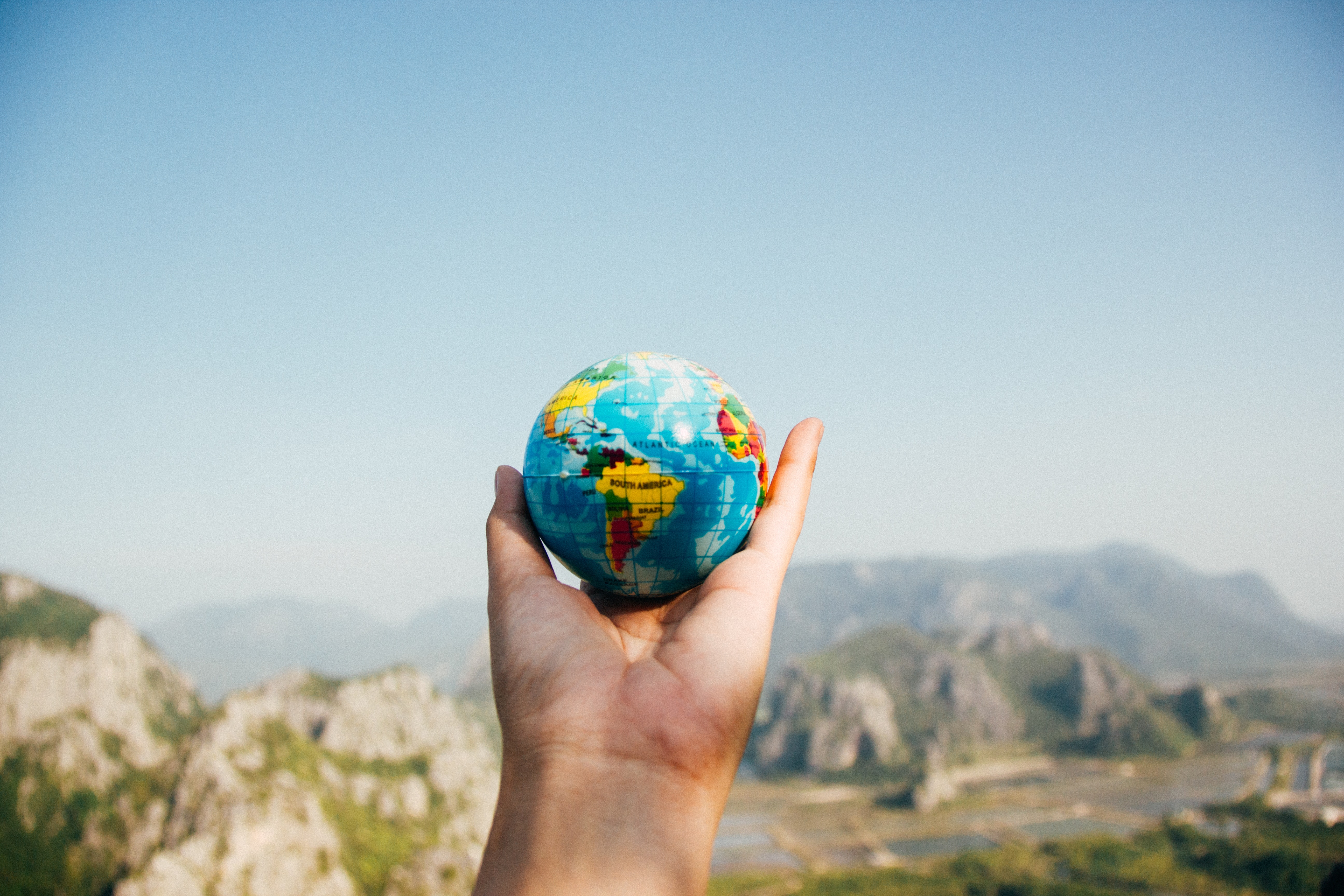 Webex Translation & Transcription: Improving Global Communication. Hand holding a globe.