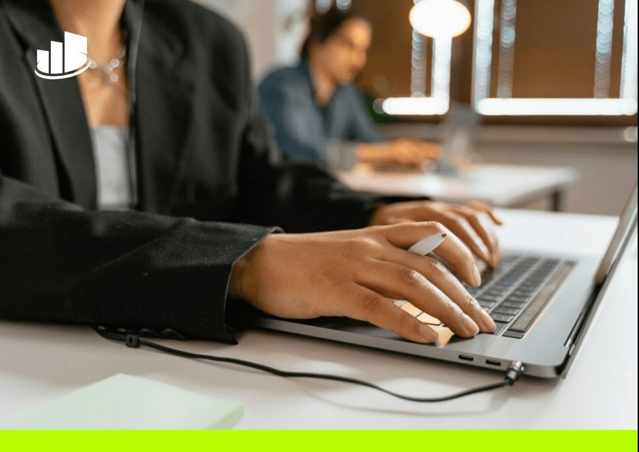 A professional working on a laptop in a modern contact center environment, focusing on digital communication and customer support solutions.