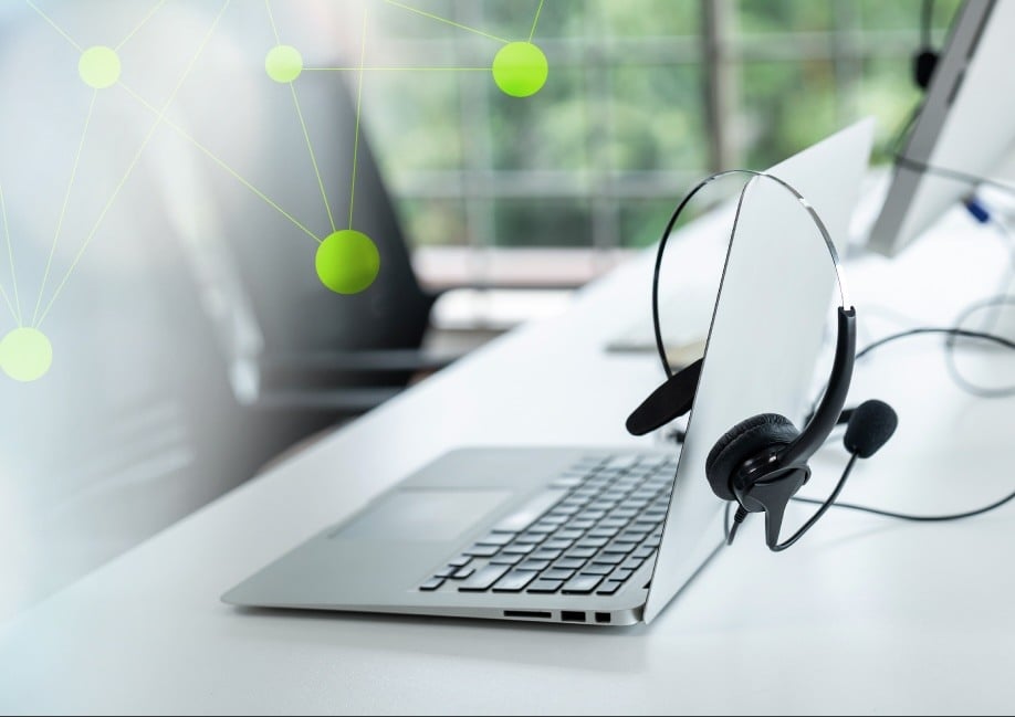 Contact Center Technology. Calling headset resting on top of a laptop.