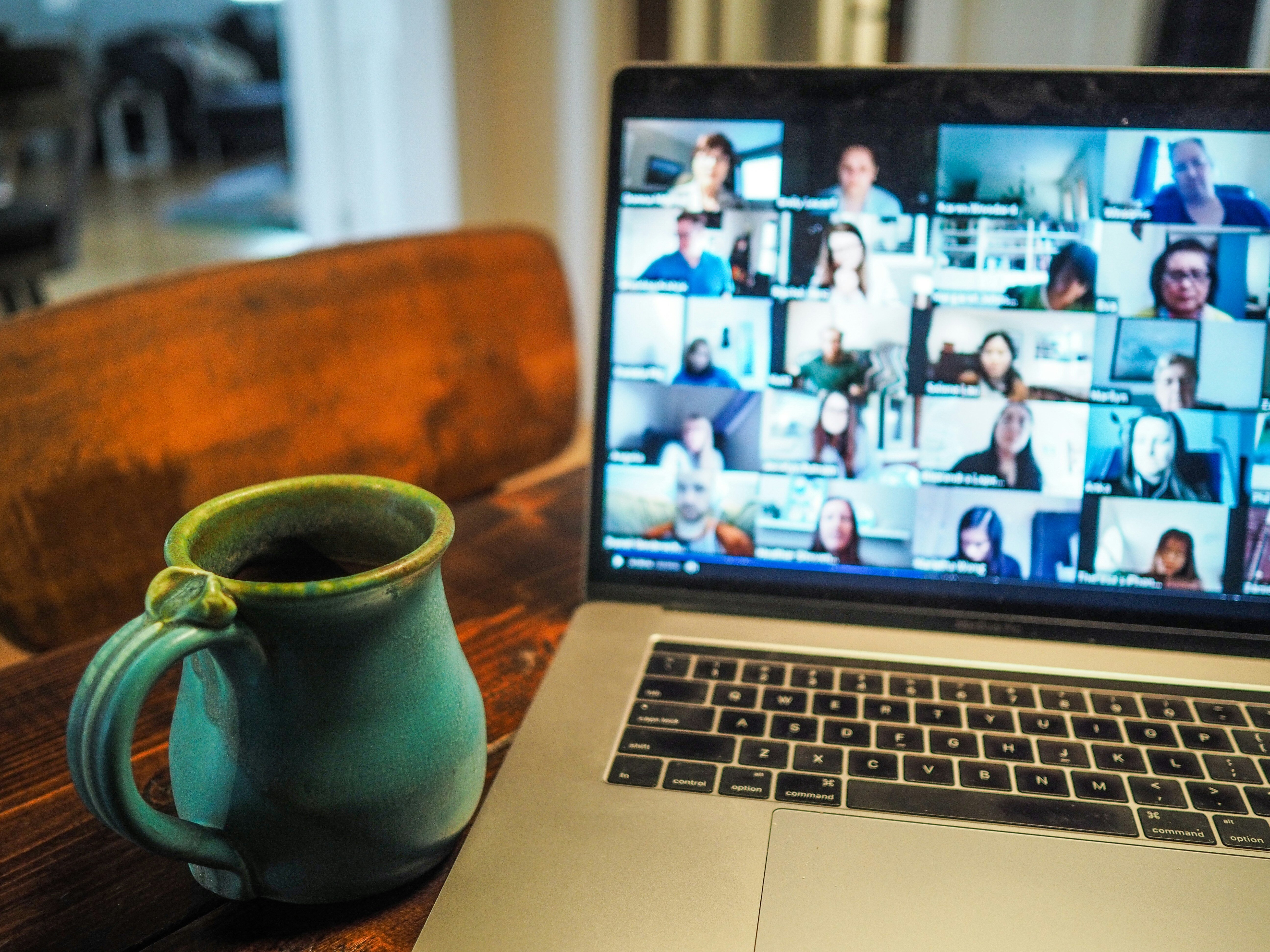 A laptop displaying a video call with multiple participants engaged in conversation.