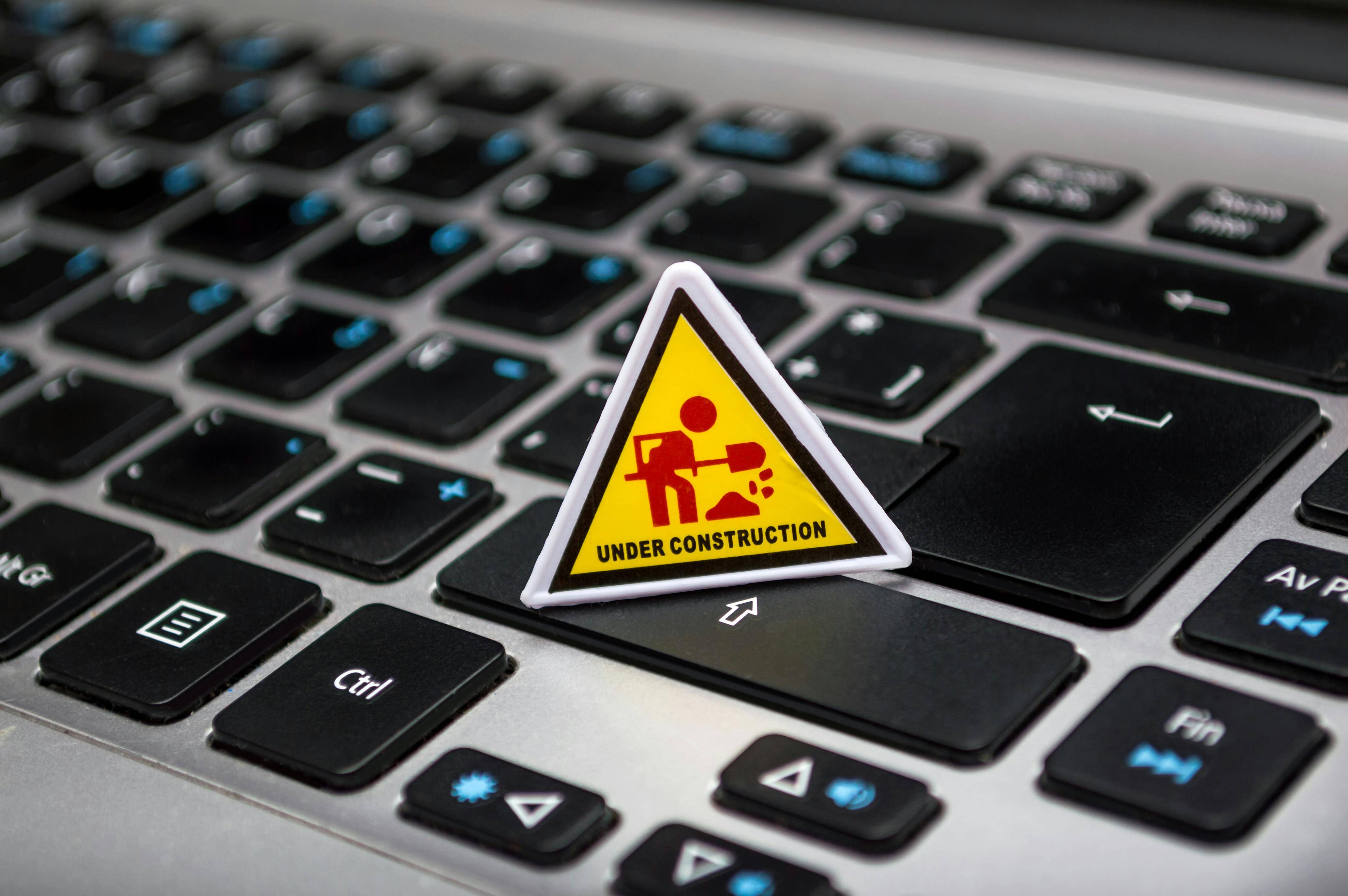 A warning sticker affixed to a laptop keyboard, indicating important safety or usage information for the device.