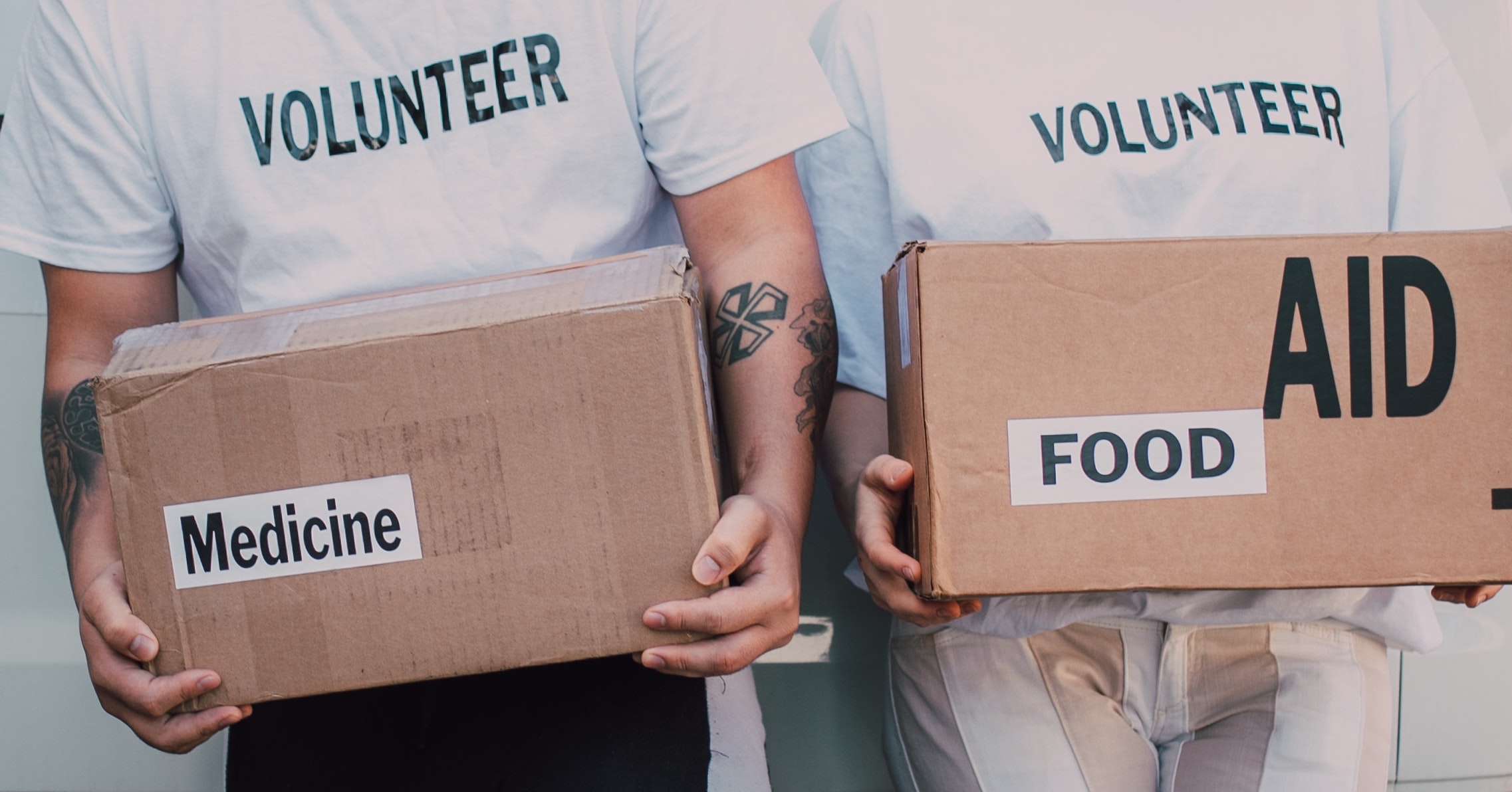 a pair volunteers holding cardboard boxes